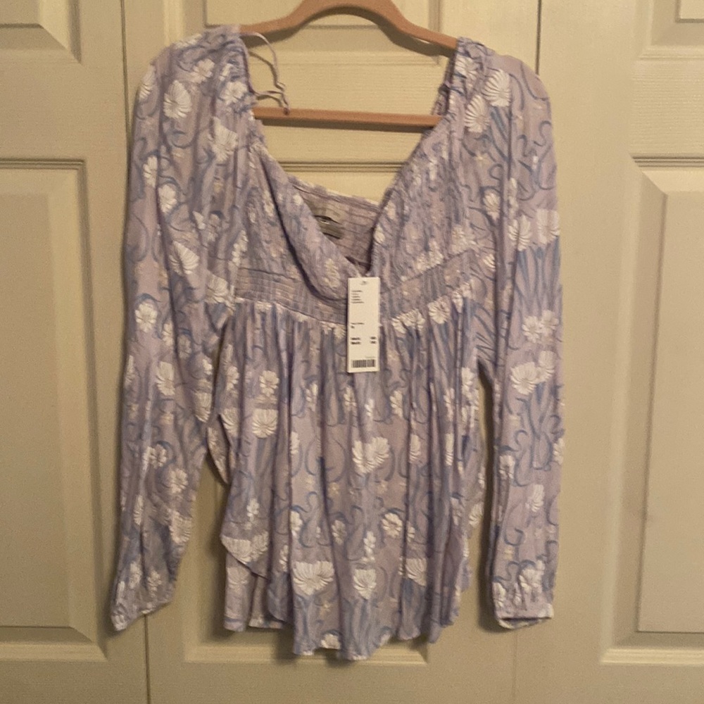Empire waist with bell sleeves and a u shaped hem, and ruching across the bust.